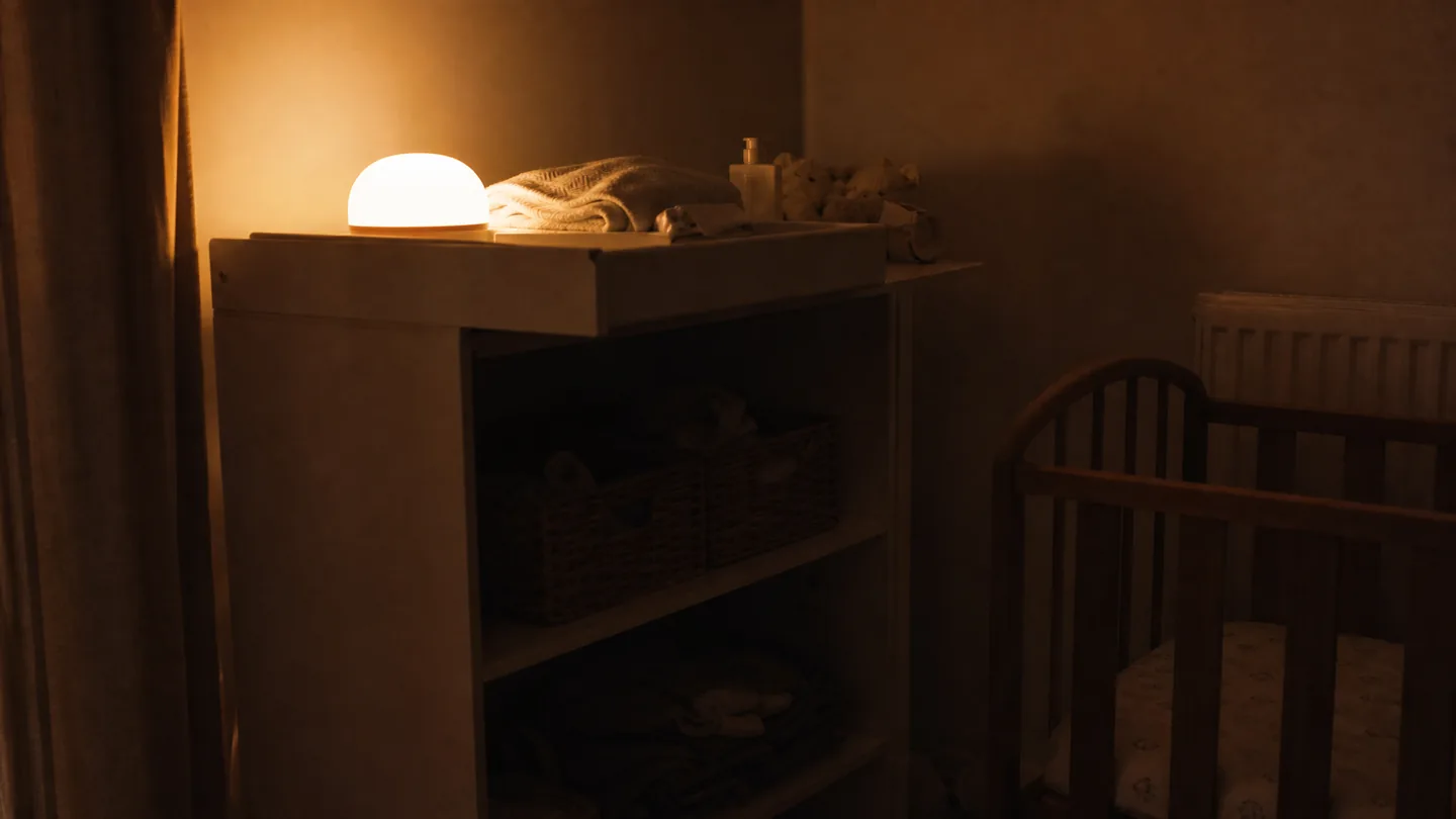 nursery, folded blanket, lamp on a shelf