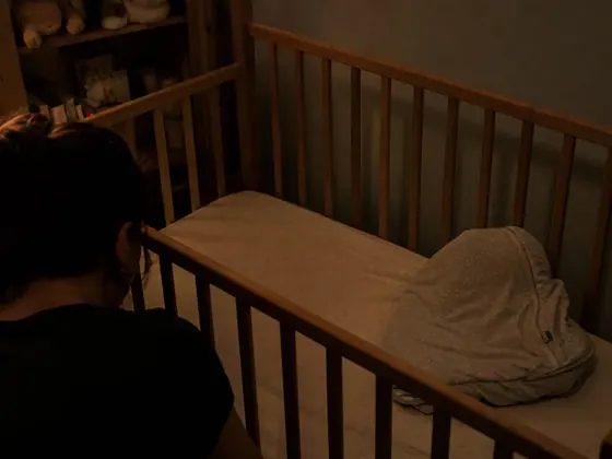 cot, standing baby, dark room