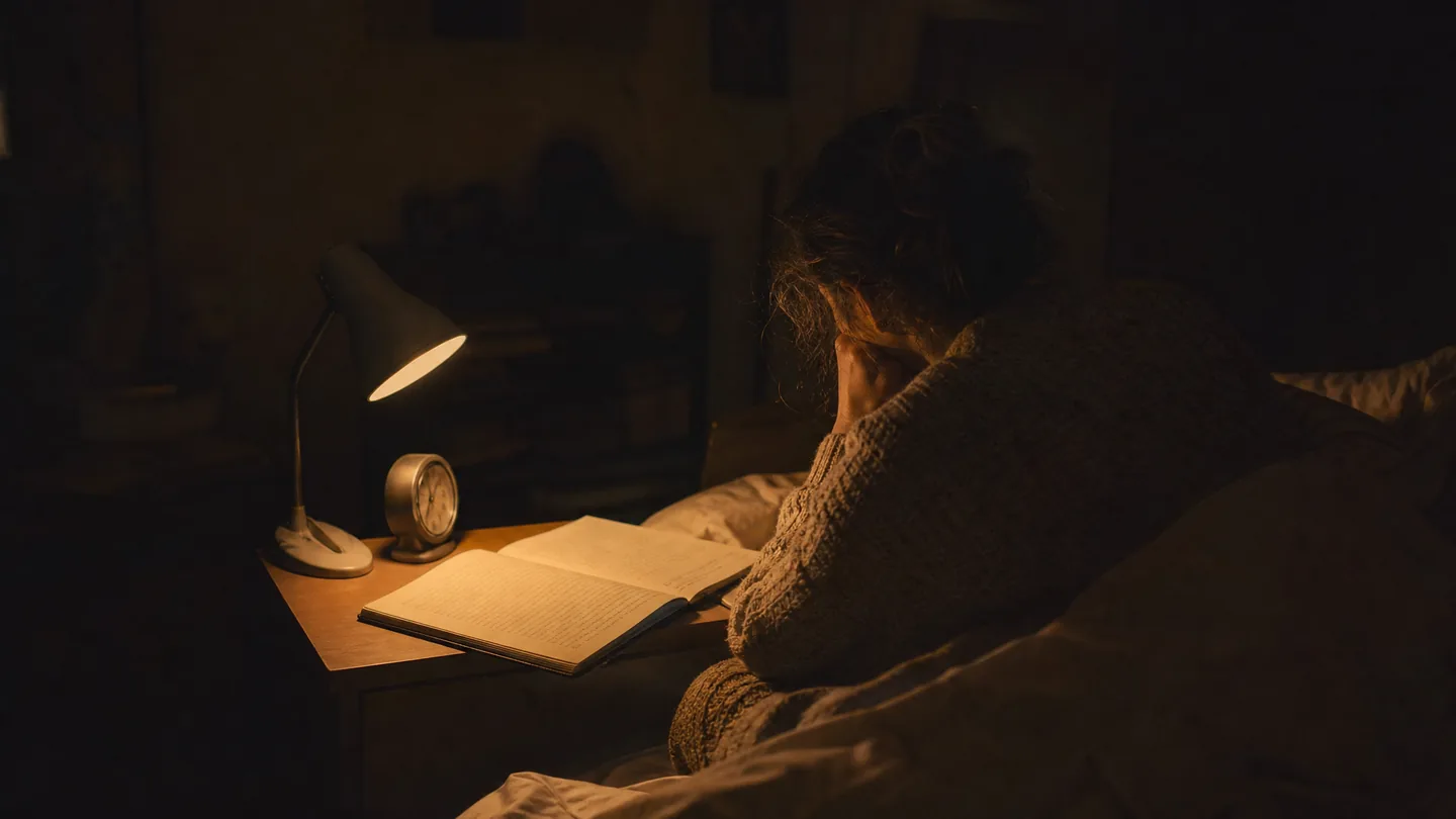 clock and a notebook on a bedside table