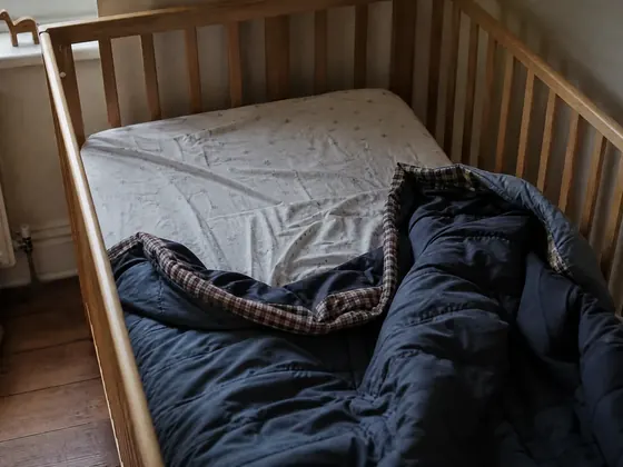 cot with a baby standing up, daytime