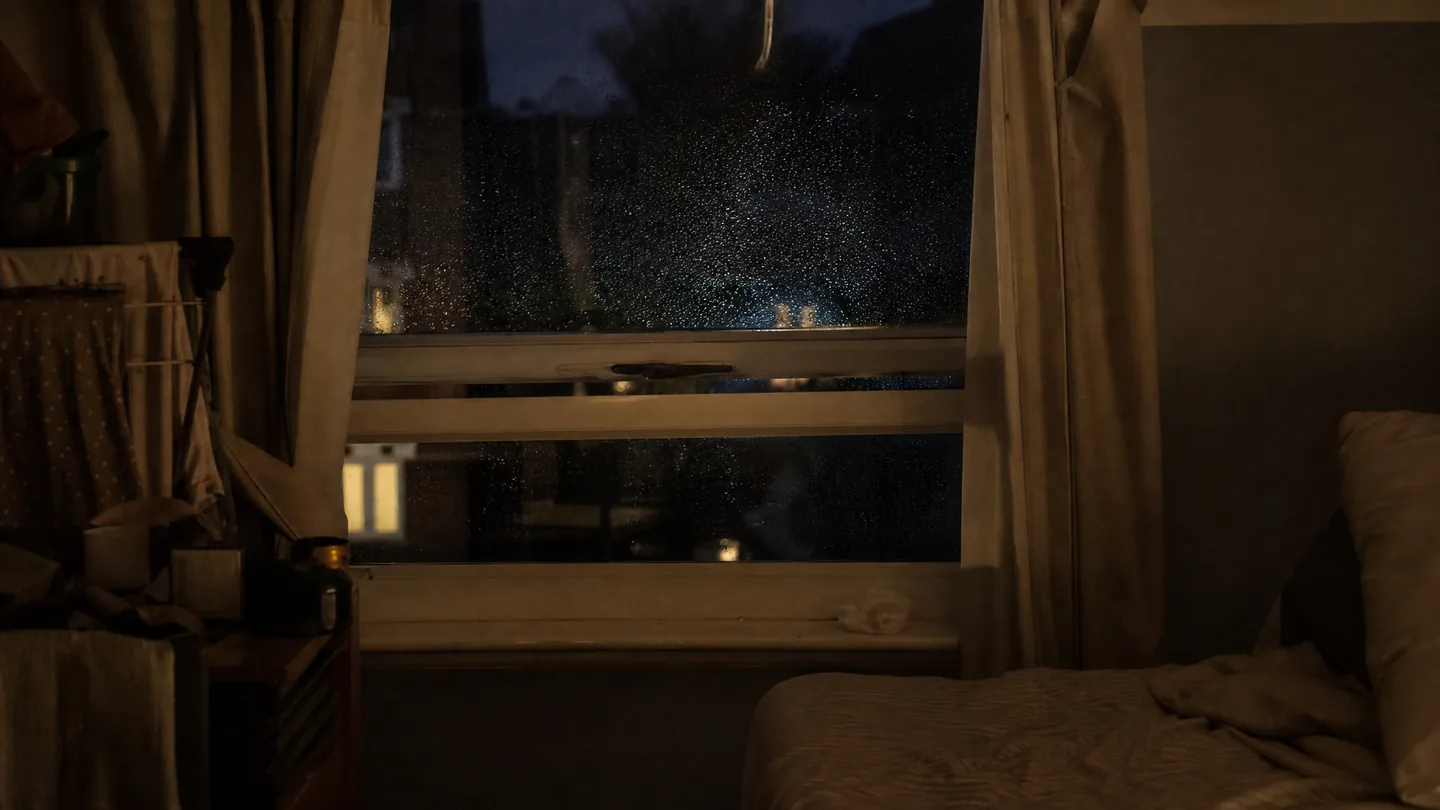 bedroom window at night, rain on the glass